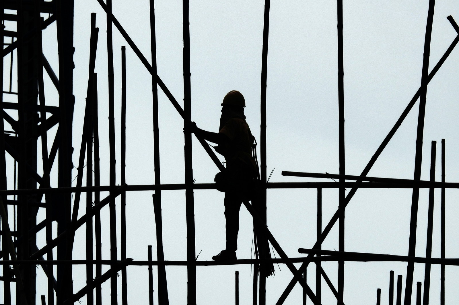 Silhouette of a worker on bamboo scaffolding
